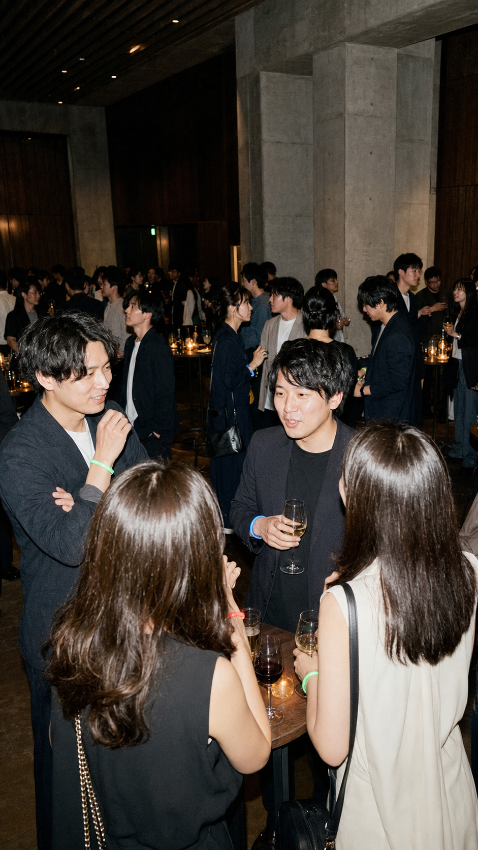 立食形式の会場で多くの参加者がグループ交流を楽しむ様子